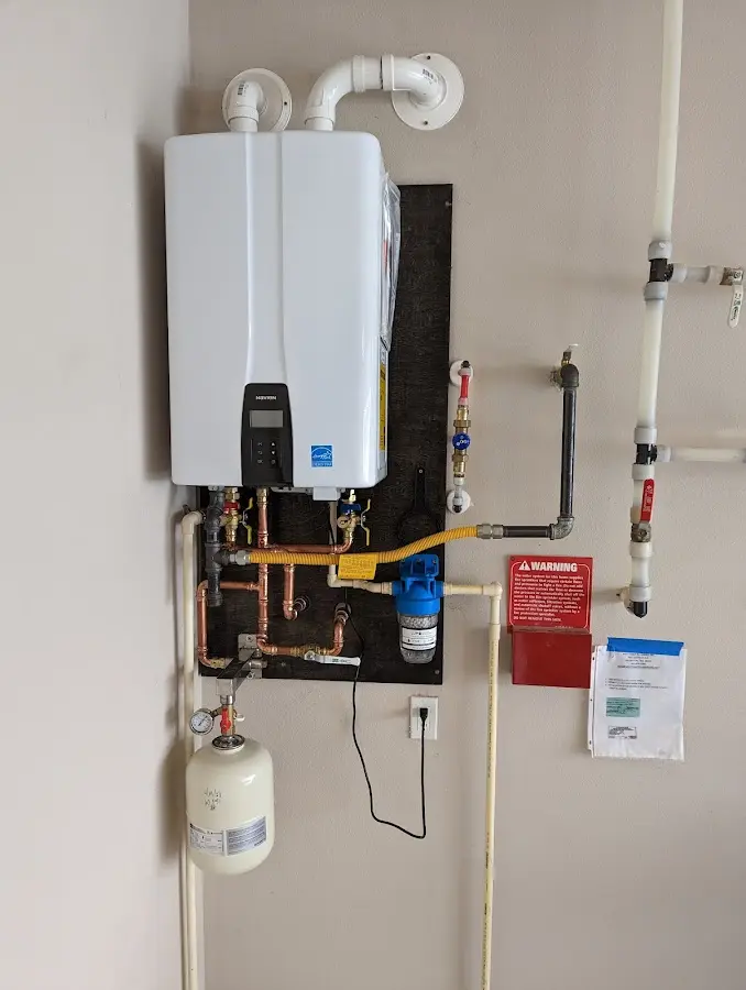 Professional plumber installing copper piping in a Mayville home